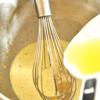 Chuyển hỗn hợp vỏ chanh vào một tô chịu nhiệt. Cho trứng vào và đánh tan. Cho từ từ nước chanh vào và hoà đều.