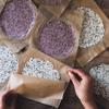 Bạn cắt giấy nướng bánh, ngắt một ít bột đã nhào cho vào giấy nướng và đặt một tờ khác lên trên và dùng thanh cán bột để cán mỏng bột.