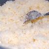 Đập trứng gà ra tô lớn. Cho dừa nạo và 80gr đường vào, trộn cho đến khi đường tan và hỗn hợp hơi dính.