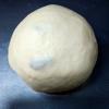 Tiếp theo, cho trứng gà, sữa tươi vào, nhào bột thật kỹ thành một khối mềm, mịn. Ấn hơi dẹp bột, cho nho vào, vo tròn lại như hình.