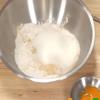 Trộn đều bột gạo, bột đậu xanh, đường với nhau. Thêm 60ml nước vào cùng bột rồi đánh đều. Sau đó, đổ lòng đỏ từ từ vào hỗn hợp bột, trộn đều đến khi được hỗn hợp đặc sệt.
