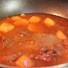 Tiếp theo, đổ khoảng 250ml nước vào, nấu sôi. Khi nước sôi, cho cà rốt, cà chua, hành tây, khoai tây vào, nấu nhỏ lửa.