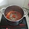 Bật bếp, bắt 1 cái chảo lên bếp, cho vào 1 muỗng canh dầu ăn. Tỏi đập dập cho vào phi thơm, đổ cà chua vào xào cho mềm để tạo màu cho nước dùng.