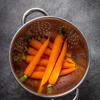 Bật lò nướng ở 180 độ C. Cà rốt rửa sạch, bỏ phần đầu và lá, gọt vỏ. Đun sôi một nồi nước. Khi nước sôi thì cho cà rốt vào luộc sơ khoảng 5 phút. Trút cà rốt ra và để ráo. 