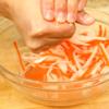 Sau khi ngâm muối, sợi cà rốt và củ cải đã mềm hơn, dùng tay vắt sạch nước còn lại trong củ cải và cà rốt cho vào tô để riêng.