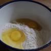 Trong tô nhỏ, trộn đều bột mì với 2 quả trứng gà, 1g bột nở, thêm nước từ từ và khuấy cho hỗn hợp đặc sánh.