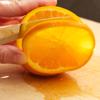 Tiếp theo, cắt cam thành từng lát mỏng. Xếp cam vào lọ thủy tinh, rắc đường lên trên mỗi lớp cam nè.