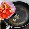 Rửa sạch cà chua và cắt múi cau. Chảo sau khi chiên sơ cá thì tận dụng luôn, cho 1 ít tỏi băm vào chảo phi thơm. Tiếp theo, cho cà chua đã cắt vào xào sơ để cà ra màu, canh sẽ đẹp mắt hơn.