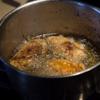 Đun sôi dầu trở lại. Thả phần gà trở lại chiên lần 2 trong khoảng 5 phút. Vớt cánh gà ra để ráo dầu trên rây. Giữ gà còn nóng và cho vào phần sốt trong chảo, trộn đều để phần sốt thấm đều vào gà.