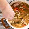 Cho thịt gà, hẹ tây, ớt chuông, nấm và tương ớt Thái Lan vào trong nồi nước hầm, đun sôi. Tắt bếp, cho thêm sữa dừa vào nồi nước hầm, dùng muỗng để khuấy đều.