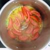 Kế tiếp cho ớt bột, cà chua vào xào gần chín thì cho hến đã trụng qua nước sôi vào. Xào thêm khoảng 1 phut thì cho nước hến vào và nêm gia vị gồm muối, bột ngọt.