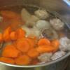 Nước sôi cho thịt viên và cà rốt vào. Khoảng 5 phút sau thêm khoai tây vào tiếp tục nấu.