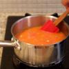 Làm nóng 2 muỗng canh dầu mè trong nồi, cho cà chua vào, xào khoảng 3 phút. Sau đó, đổ 2 chén nước vào, nấu sôi.