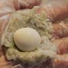 Dùng muỗng múc một ít hỗn hợp tôm vào tay đeo nylon. Tiếp theo đặt vào giữa lòng chả tôm một quả trứng cút. Vo tròn viên chả tôm để khít quả trứng cút, làm cho hết phần tôm và trứng.