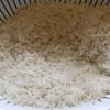 Gạo tẻ vo sạch, đổ ra rổ cho ráo nước. Sau đó, rang sơ qua gạo với lửa nhỏ, để hạt gạo săn lại.
