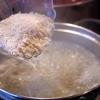 Cho gạo tẻ vào chảo, để lửa vừa, rang đến khi hạt gạo đục, có hương thơm thì dùng chày đập dập hạt gạo rồi vào nồi nước luộc ở trên, đun trong khoảng 1 giờ 30 phút cho cháo chín.