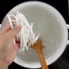 Đun sôi 500ml nước, dùng vá khuấy để nước tạo thành dòng, sau đó cho từng nắm bánh canh vào luộc. Lúc này sợi bánh canh hơi mềm chưa được dai nên hạn chế khuấy mạnh sẽ làm đứt sợi bánh. 