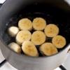 Cho 72g đường nâu và 120ml nước lọc vào nồi, khuấy tan sau đó cho chuối và hạt dẻ vào nấu sôi thì giảm lửa. Đun đến khi phần nước ngả sang màu vàng nhạt thì tắt bếp.