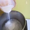 Trong một nồi khác, cho nước cốt dừa, 100gr đường trắng vào nồi, khuấy đều 2 phút. Tắt bếp, để nguội.