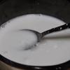 Trong một nồi khác, cho nước cốt dừa, 30gr đường trắng vào, khuấy đều khoảng 3-5 phút.