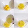 Đánh lòng đỏ trứng với đường.Chia dầu bắp thành 3 phần, lần lượt cho vào lòng đỏ trứng. Cứ mỗi một lần cho vào lại đánh đều rồi mới đổ tiếp lượt dầu mới.
