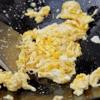 Để chảo nóng, cho ít dầu ăn vào chảo, cho trứng gà vào dùng đũa quấy cho trứng tơi thành từng sợi nhỏ.