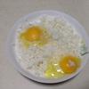 Đập 2 quả trứng cho vào tô cơm. Thêm vào 1g tiêu trắng và 2-3g muối, trộn cho cơm quyện đều trứng.