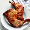 Thịt gà nướng chín cho ra đĩa, ở giữa để cơm, xung quanh đùi gà, đồ chua và dưa leo ăn kèm.