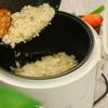Cho gạo đã xào vào trong nồi cơm điện, đổ nước vào xâm xấp mặt. Tỉ lệ và nước là 1:1 nhé. Bật nút 