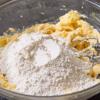 Đánh bơ với đường cho bơ trắng ra và đường tan bớt.  Rây bột vào trộn, cuối cùng thêm tinh chất vanilla rồi trộn đều. Bước này sẽ tốn một vài phút, lúc đầu hỗn hợp sẽ trở nên nhão rồi cuối cùng mới thành dạng bột.