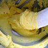 Đánh bơ còn lại mềm bằng máy trộn với một chiếc phới trong vài phút, sau đó tiếp tục cho 225g đường, 30ml nước cốt chanh và 1 ít màu thực phẩm vàng, tất cả trộn đều.