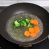 Cà rốt gọt vỏ thái lát mỏng. Bông cải xanh thái nhỏ rửa sạch. Đem luộc cà rốt và bông cải xanh trong nước sôi khoảng 2 phút, vớt ra để ráo.