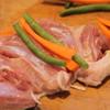Trải miếng thịt gà ra thớt, xếp bên trên cà rốt, đậu, dùng tay cuộn tròn lại.