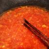 Dùng một cái chảo sâu lòng khác, phi thơm tỏi băm rồi trút cà chua vào xào, cho thêm ít nước lọc, 2 muỗng canh sốt cà chua vào cùng.