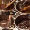 bẻ nhỏ chocolate, cho vào nồi, đun nhỏ lửa cách thủy cho tan chảy. Thêm vào 80ml nước sôi, đun và khuấy đều.