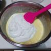 Tiếp đến, trong 1 thố sạch khác, đánh bông 150g kem whipping rồi đổ kem vào thố trứng phô mai, dùng spatula trộn cho chúng quyện đều thành hỗn hợp đồng nhất.