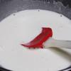 Đập trứng gà ra chén, tách lấy lòng đỏ trứng, thêm đường trắng vào, đánh đều. Nấu sữa tươi không đường và kem whipping trong nồi đến khi sữa sôi quanh mép nồi.