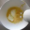 Đổ 1/2 hỗn hợp sữa tươi đã nấu vào hỗn hợp trứng gà, đánh đều cho hỗn hợp đồng nhất.