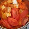 Thêm tí nước lạnh nấu cho đến khi cà rốt và khoai tây mềm, nước trở nên hơi sệt thì cho cà chua và đậu hũ vào.