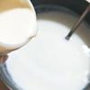 Cho sữa chua mua sẵn vào nồi sữa vừa đun ấm và khuấy đều tay.