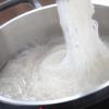 Mì gạo rửa sạch trước 2 nước cho mềm. Đun sôi nồi nước, cho mì vào luộc sơ cho đến khi mềm thì vớt ra rổ thưa cho ráo.