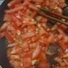 Xào cà chua, thêm nước và nước sốt cà chua, dùng muỗng ép nhẹ cho phần thịt cà chua nát mềm. Thêm nấm và hạt nêm, tiếp tục xào thêm 2 - 3 phút.