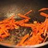 Đun nóng 1 muỗng canh dầu ăn, phi hành tím băm thơm, cho cà rốt vào xào khoảng 2 phút.