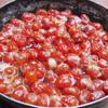 Cho cà chua và cả nước đường ướp cà chua vào chảo. Đăt chảo lên bếp đun sôi, sau đó hạ lửa xuống mức nhỏ. Thỉnh thoảng cầm chảo nghiêng qua nghiêng lại cho nước đường chảy tràn lên mặt cà chua để cà chua được ngấm đều đường.