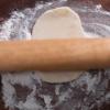 Bạn rắc bột mì lên mặt thớt, cho miếng bột lên thớt sau đó dùng cán cán mỏng từng miếng bột. Bạn phết bơ nhạt, rắc bột ớt và thêm 1 - 2 muỗng canh kim chi vào giữa. Cuộn miếng bột thành hình bầu dục, gấp mép bánh lại rồi dùng tay ấn miếng bột cho dẹp. Sau đó cán mỏng miếng bánh. Bắc chảo lên bếp, bật bếp ở lửa vừa, cho dầu ăn vào chảo đun nóng. Cho bánh vào chiên mỗi mặt khoảng 2 - 3 phút đến khi có lớp vỏ giòn sẽ ngon hơn nhé!