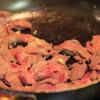 Tiếp tục dùng chảo đó, phi thơm tỏi băm, cho thịt bò vào, xào khoảng 5 phút. Sau đó, cho tôm, cải thìa, hành tây vào xào cùng.