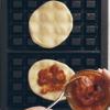 Làm nóng máy nướng bánh waffle, quét một lớp dầu mỏng rồi trải 2 miếng bột bánh lên, cho lần lượt ít sốt cà chua, phô mai, lá húng quế, sốt pesto lên, dùng 2 miếng bánh khác đậy lại. Gập máy xuống và nướng trong khoảng 3-4 phút hoặc đến khi bánh chín vàng.