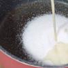 Phần pudding đậu nành: cho 600g đường trắng vào nồi, chế 500ml sữa đậu nành vào. Bắc nồi sữa lên bếp nấu trên lửa nhỏ, khuấy đều cho đường tan hết và sữa hơi ấm là được. Không nấu sôi bạn nhé. Sau đó cho 7g bột gelatin vào sữa, khuấy đều lên cho hòa tan hết.