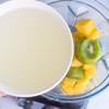 Chuẩn bị các loại trái cây rửa sạch. Kiwi gọt vỏ thái lát. Xoài gọt vỏ thái hạt lựu. Chuối bóc vỏ. Bạn cho kiwi và xoài vào máy xay sinh tố, thêm chuối và nước dừa tươi xay nhuyễn. Tùy theo khẩu vị gia đình, bạn có thể thêm đường sữa tùy thích.