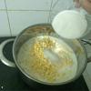 Tiếp theo cho bắp đã tách hạt và cùi bắp vào nồi, thêm 250ml sữa tươi và 150g đường trắng vào.
